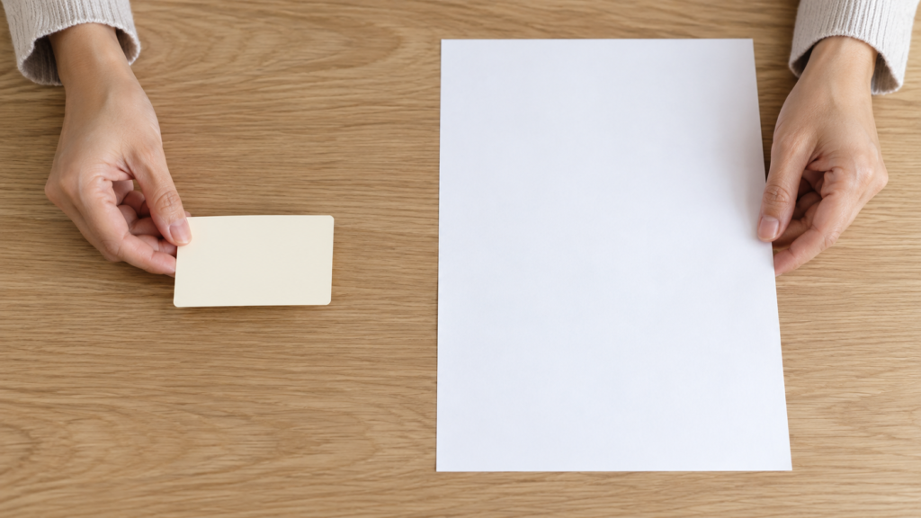 カード状の紙と大きな書類を分けて並べたイメージ